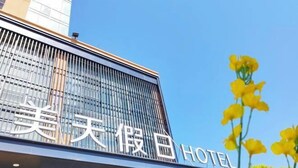 A hotel building with a modern facade and large windows. - Meitian Holiday Hotel (Shaanxi University of Technology) (Hanzhong)