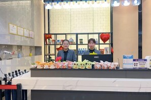 Un mostrador de recepción con un mostrador que exhibe varios artículos, incluyendo peluches y un letrero con el logo 'HKC'.