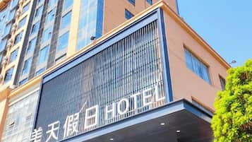 A hotel with a modern facade, large windows, and a prominent sign.
