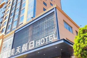 Un hotel con fachada moderna, ventanas grandes y un letrero llamativo.