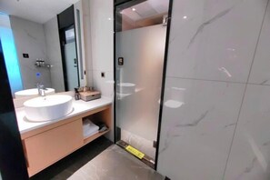 A modern bathroom with two sinks, a glass shower enclosure, and a marble floor. - Meitian Holiday Hotel (Shaanxi University of Technology) (Hanzhong)