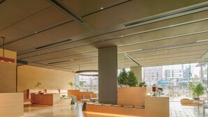 Eine großzügige Lobby mit hoher Decke, modernen Möbeln und großen Fenstern mit Stadtblick.