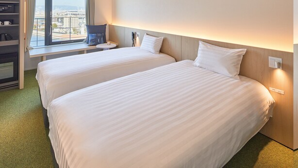 A hotel room with two beds, a desk, a view of the city, and a minibar. - Dorsett by Agora Osaka Sakai (Sakai)