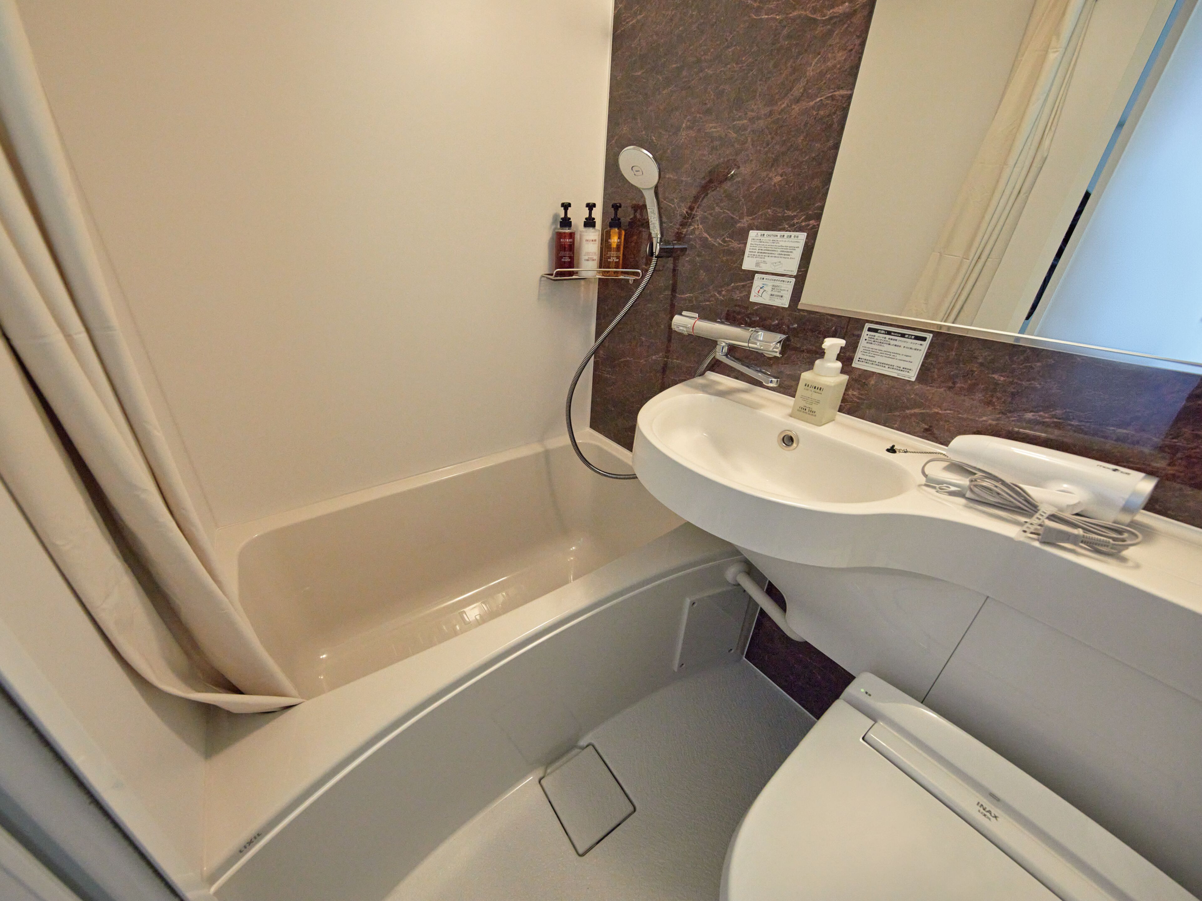 Et badeværelse med badekar, håndvask og toilet.