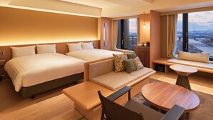 A hotel room with two beds, a sofa, a dining table, and a view of the city. - Dorsett by Agora Osaka Sakai (Sakai)