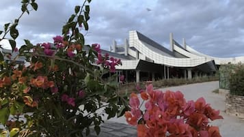 Un bâtiment moderne doté d’un toit incurvé et d’un chemin menant à l’entrée.