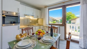 Une cuisine moderne avec un coin repas, une grande fenêtre et une vue sur l’extérieur.