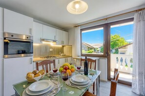 A modern kitchen with a dining area, a large window, and a view of the outside.