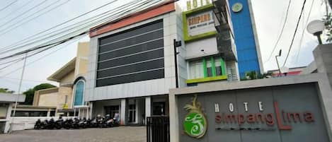 A hotel entrance with a sign reading 'HOTEL Simpang Lima.'