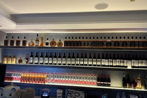 A bar area with shelves of various liquor bottles. - Bonjour Youth Hostel (Shenzhen)