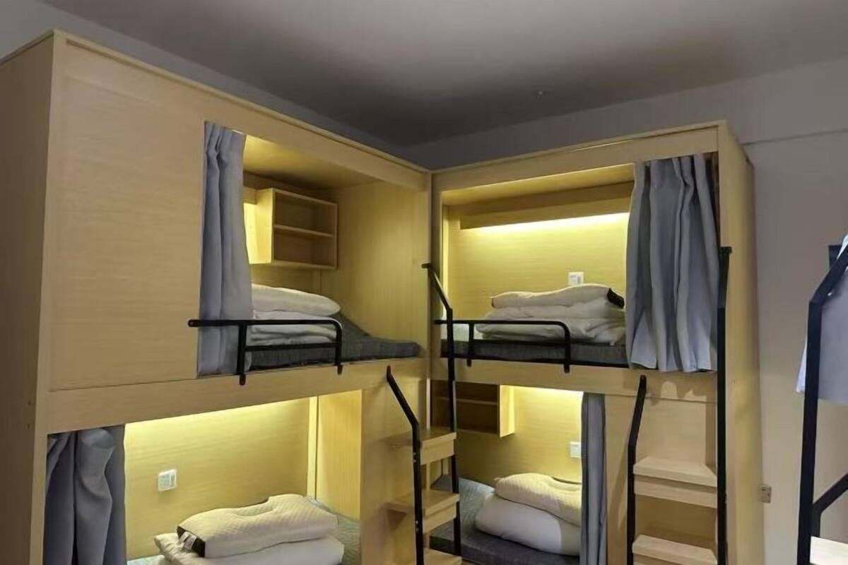 A bunk bed room with wooden walls and a built-in shelf.