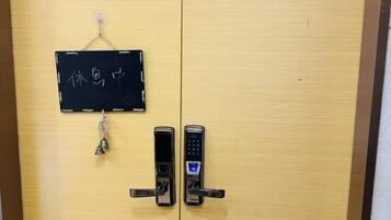 Una puerta de madera con dos cerraduras electrónicas y un letrero con caracteres chinos.