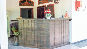 A reception area with a tiled counter, a potted plant, and a decorative vase with flowers. - Ynot Udawalawa Safari & Resort (Udawalawa)