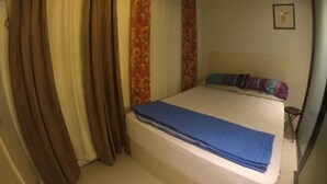 A bedroom with a bed, curtains, and a framed picture on the wall. - La Casa Parañaque (Paranaque)