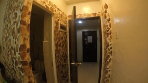 A hallway with stone walls and a door leading to another room. - La Casa Parañaque (Paranaque)