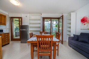 Una cocina moderna con comedor, refrigerador y sofá.