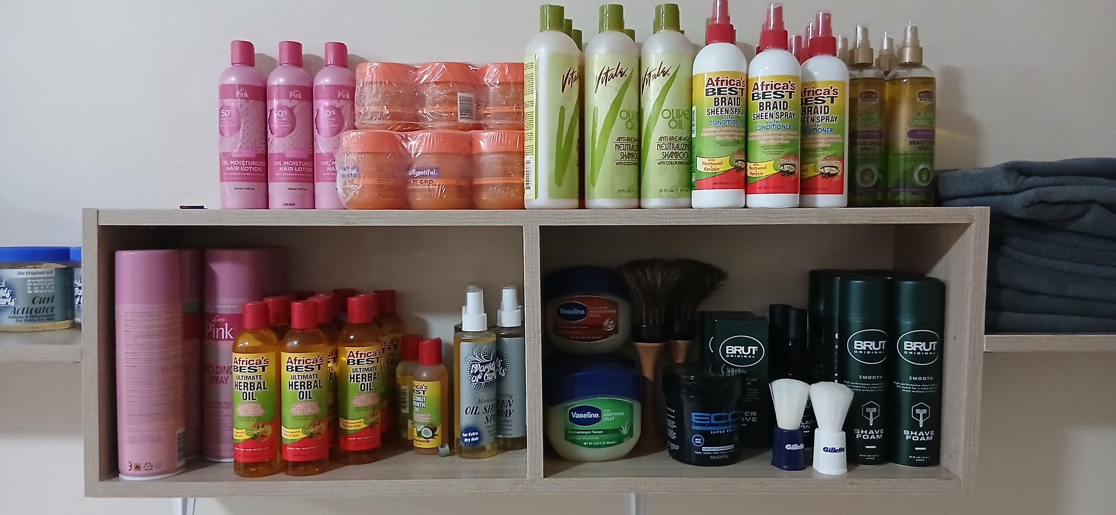 A shelf with various hair care products including shampoos, conditioners, and oils.