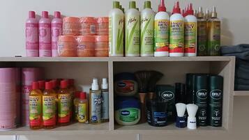 A shelf with various hair care products including shampoos, conditioners, and oils.