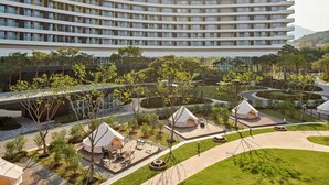 Ein Gebäude von Lotte Hotels & Resorts mit mehreren Etagen, Außenbereichen zum Sitzen und Zeltdachunterkünften.