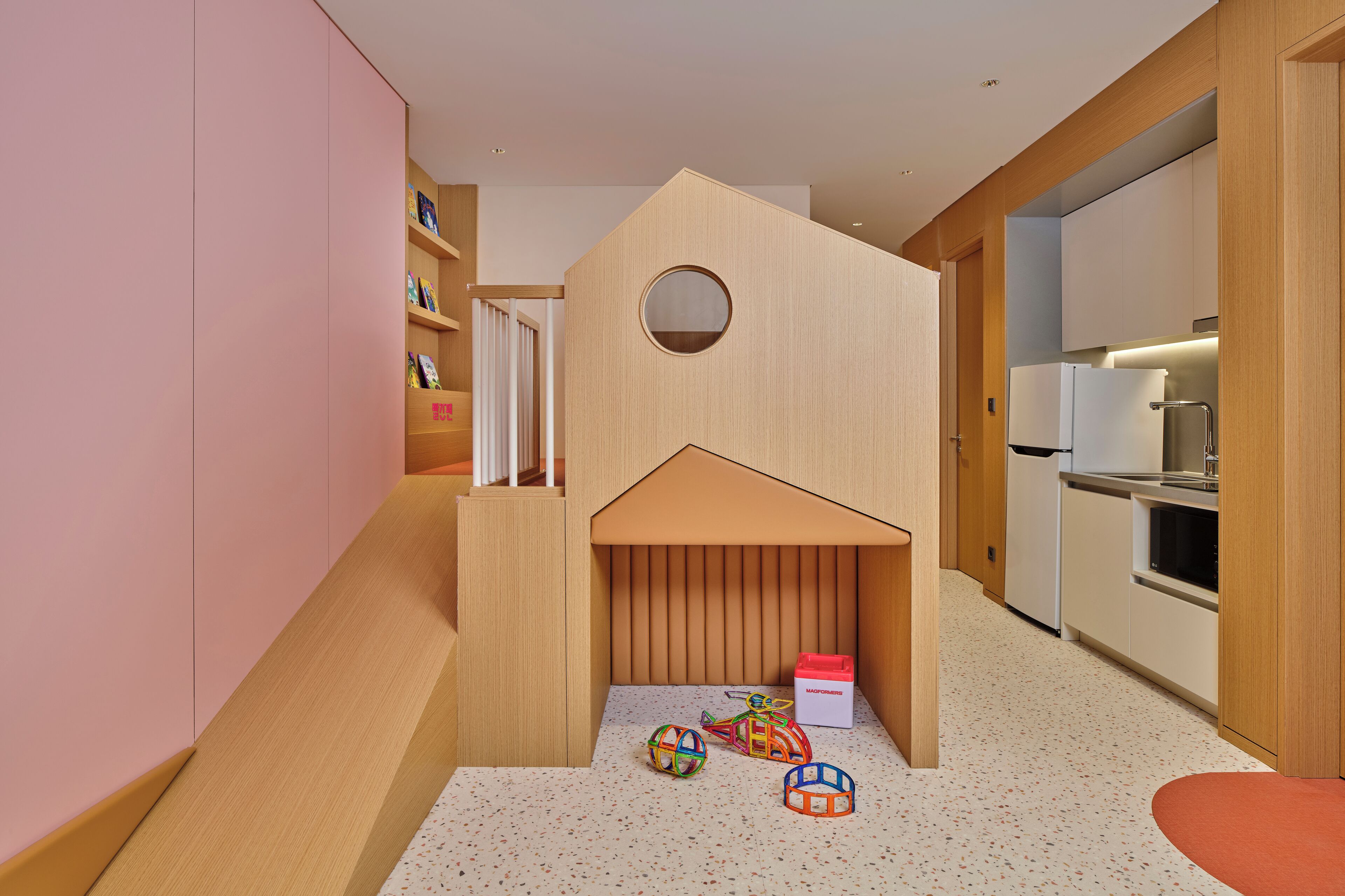 A modern kitchen with wooden cabinets, a built-in oven, and a refrigerator.