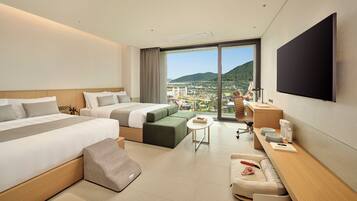 Una habitación de hotel con una cama grande, un sofá, un escritorio y una televisión.