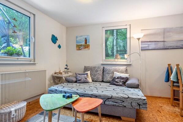 A cozy bedroom with a bed, a small table, a chair, and a radiator.