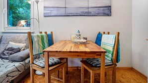 Un coin repas avec une table en bois, des chaises, une lampe et un tableau au mur.