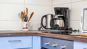 Une cuisine équipée d’une machine à café, d’ustensiles de cuisine et d’un grille-pain.