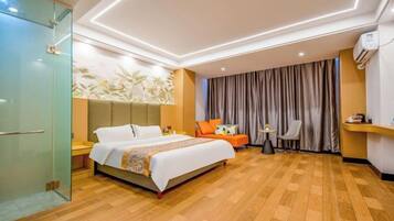 Una habitación de hotel con cama, escritorio, silla, armario y cortina.
