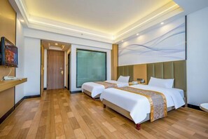 A hotel room with two beds, a TV, a desk, and a large window. - New World Holiday Hotel (Lingshui City) (Lingshui)