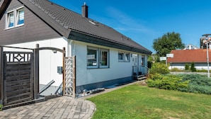 A two-story house with a dark roof, white walls, and a brick pathway leading to the entrance. - Apartment 'Fewo Georg' with Wi-Fi (Pfullendorf)