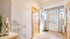 Ein Flur mit einer Holztür, einem Metallgestell und einem gemusterten Boden.