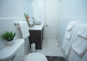 Een haardroger, handdoeken, zeep, toiletpapier