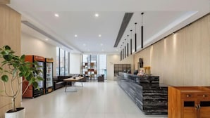 A modern hotel lobby with a reception desk, seating area, and vending machines. - Mai Peng Hotel (Qingguo Lane, Changzhou Railway Station) (Changzhou)