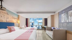A hotel room with two beds, a sofa, a desk, and a large window with a city view. - Mai Peng Hotel (Qingguo Lane, Changzhou Railway Station) (Changzhou)