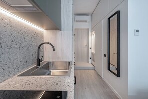 Een koelkast met diepvriezer, een microgolfoven, een kookplaat