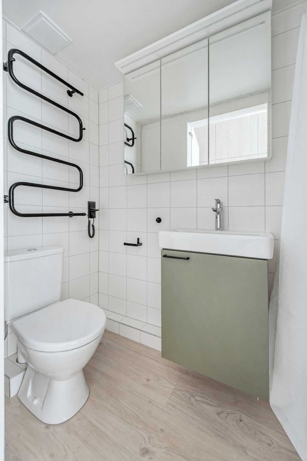 A bathroom with a toilet, a sink, and a mirror.