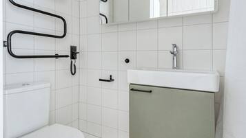 Une salle de bain avec des toilettes, un lavabo et un miroir.
