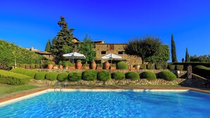 A swimming pool with a stone border, surrounded by well-manicured hedges and a stone wall. - Tuscany Country Retreat for 12 at Santo Stefano Winery near Greve in Chianti (Firenze)