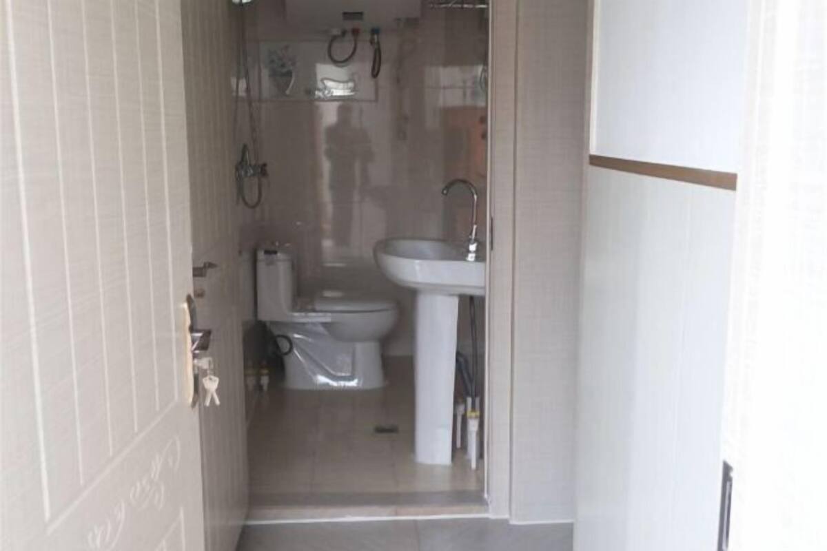 Een badkamer met toilet, wastafel en douche.