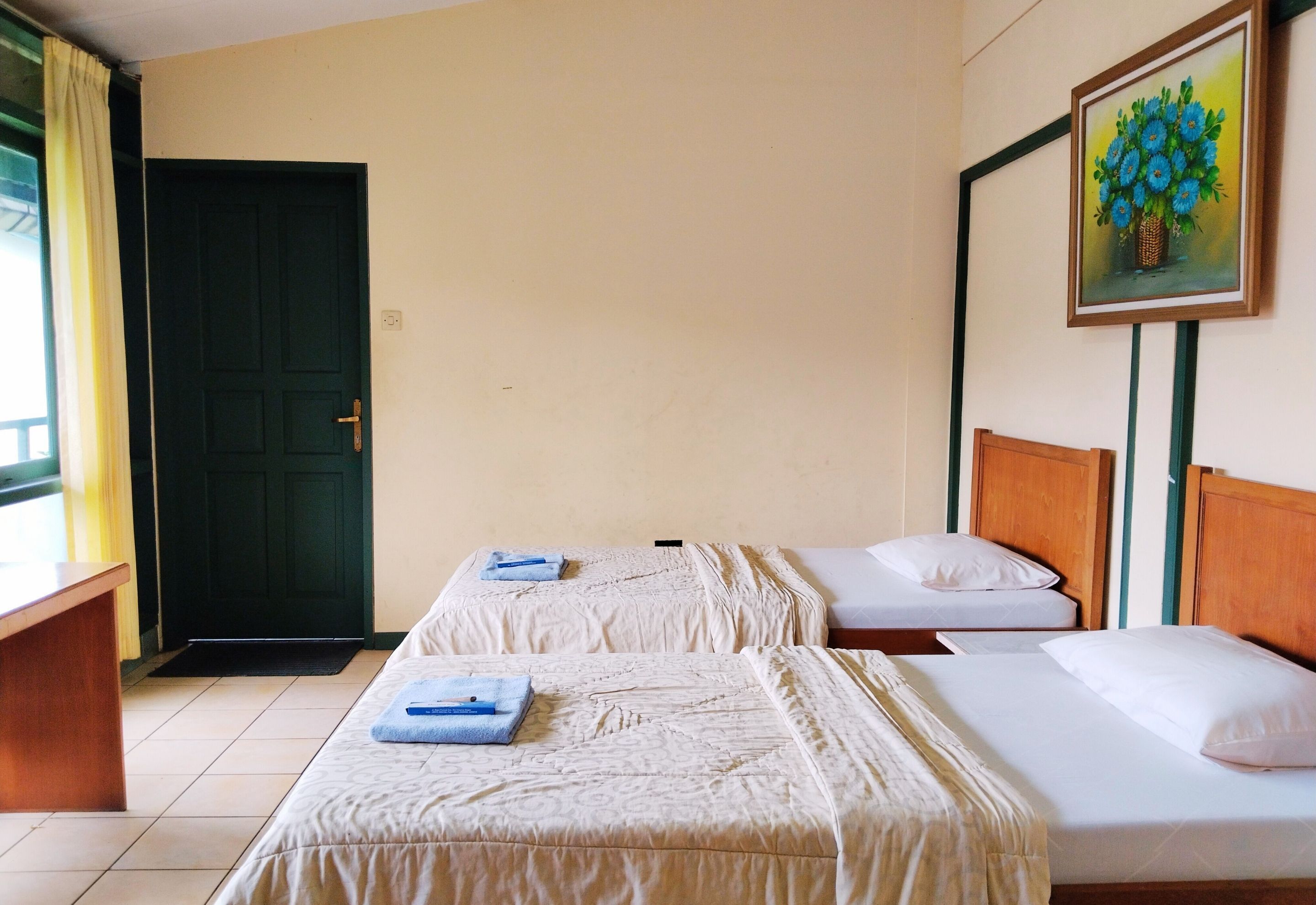 Une chambre d’hôtel avec deux lits, un bureau et une porte.