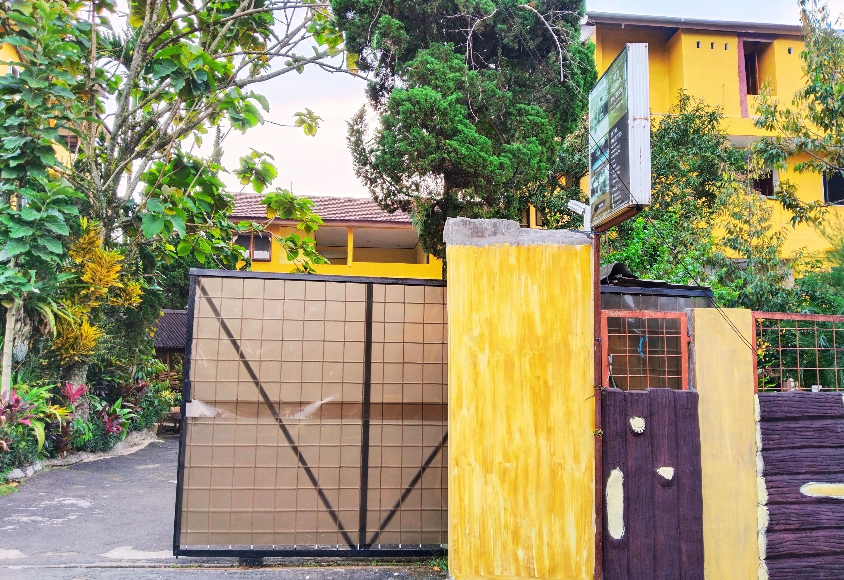 A gated entrance with a metal gate and a wooden fence.