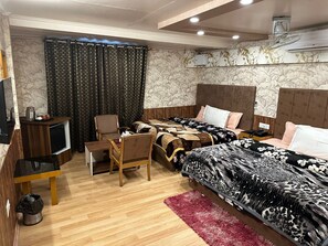 A hotel room with two beds, a desk, a chair, a TV, and a red rug. - Hotel Golden Palm By Rattans By GRB (Srinagar)
