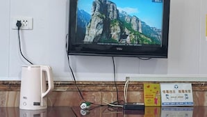 A television mounted on a wall displaying a mountainous landscape.
