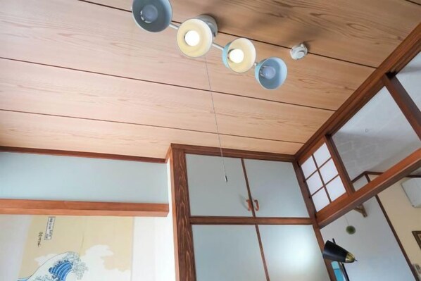 Una habitación con techo de madera y una puerta corredera tradicional japonesa.