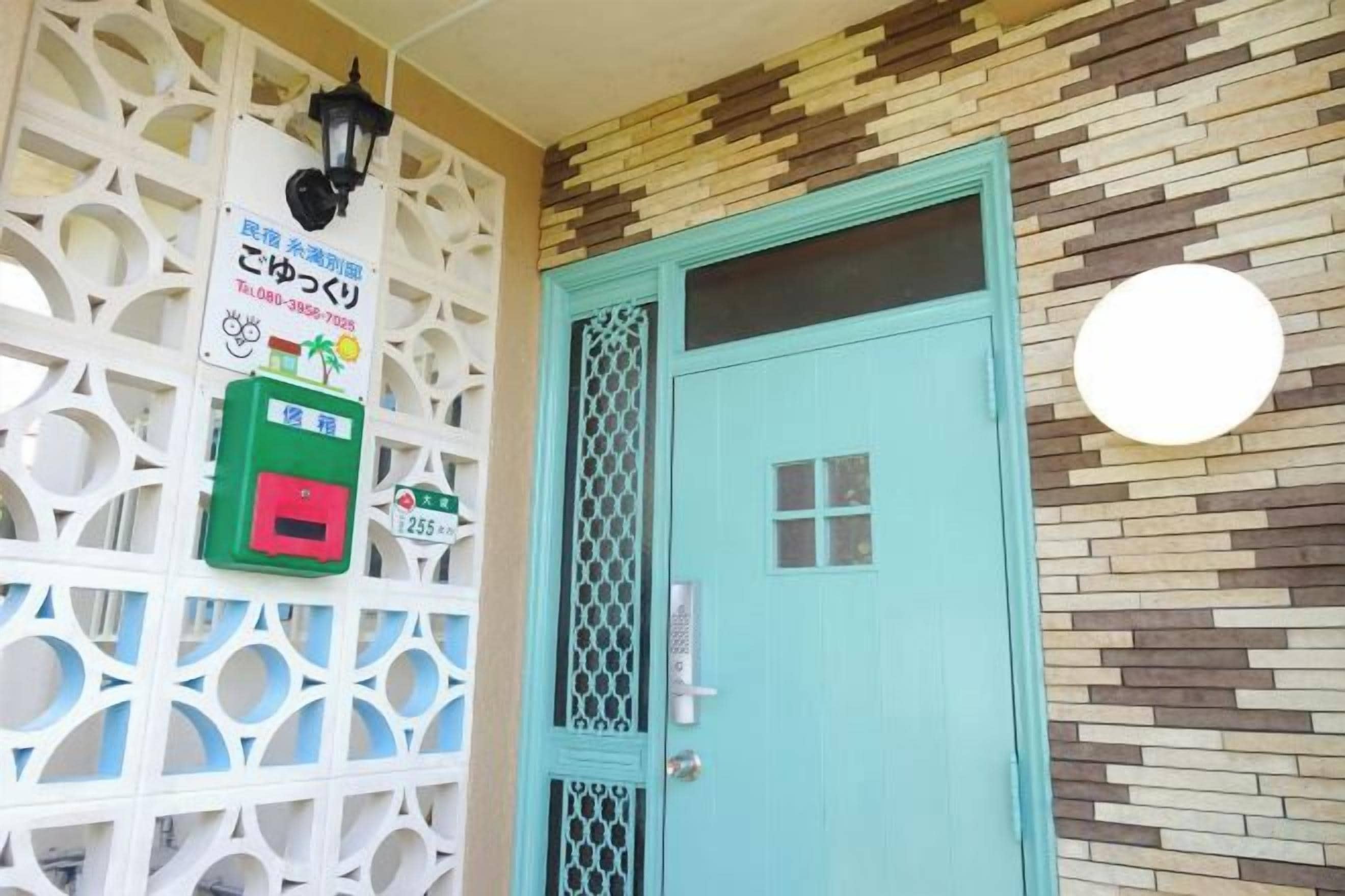 A teal door with a security lock, a green payment machine, and a decorative wall with a geometric pattern.