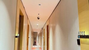 A hotel hallway with a camera on the ceiling, doors on the left, and a sign with the number 8201 on the right. - Tianshun Hotel (Guangzhou ERGONG subway station store) (Guangzhou)
