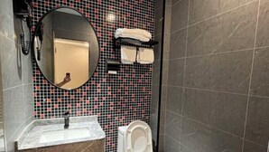 A bathroom with a marble sink, a toilet, a mirror, and a tiled wall. - Tianshun Hotel (Guangzhou ERGONG subway station store) (Guangzhou)