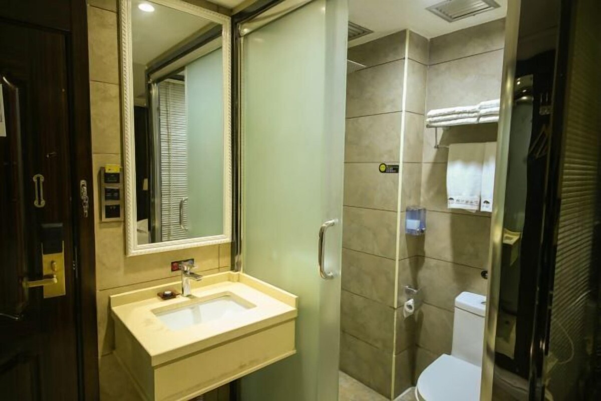 Une salle de bain équipée d’un lavabo, d’un miroir, de toilettes et d’une douche.