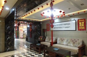 A hotel lobby with a checkered floor, a sofa, and a coffee table.